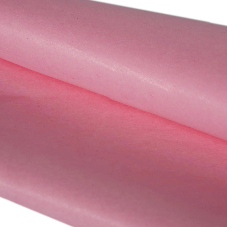Close-up of pink silk tissue paper with a subtle texture on a white background
