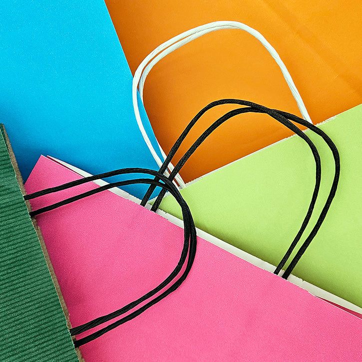Close up of different coloured twist handle paper bags for retail and gifts